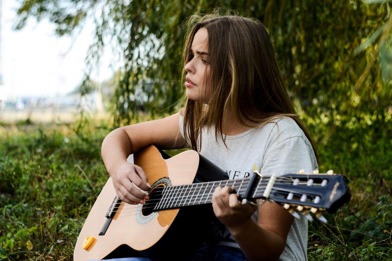 Girl Playing Guitar and Singing Song Lyrics
