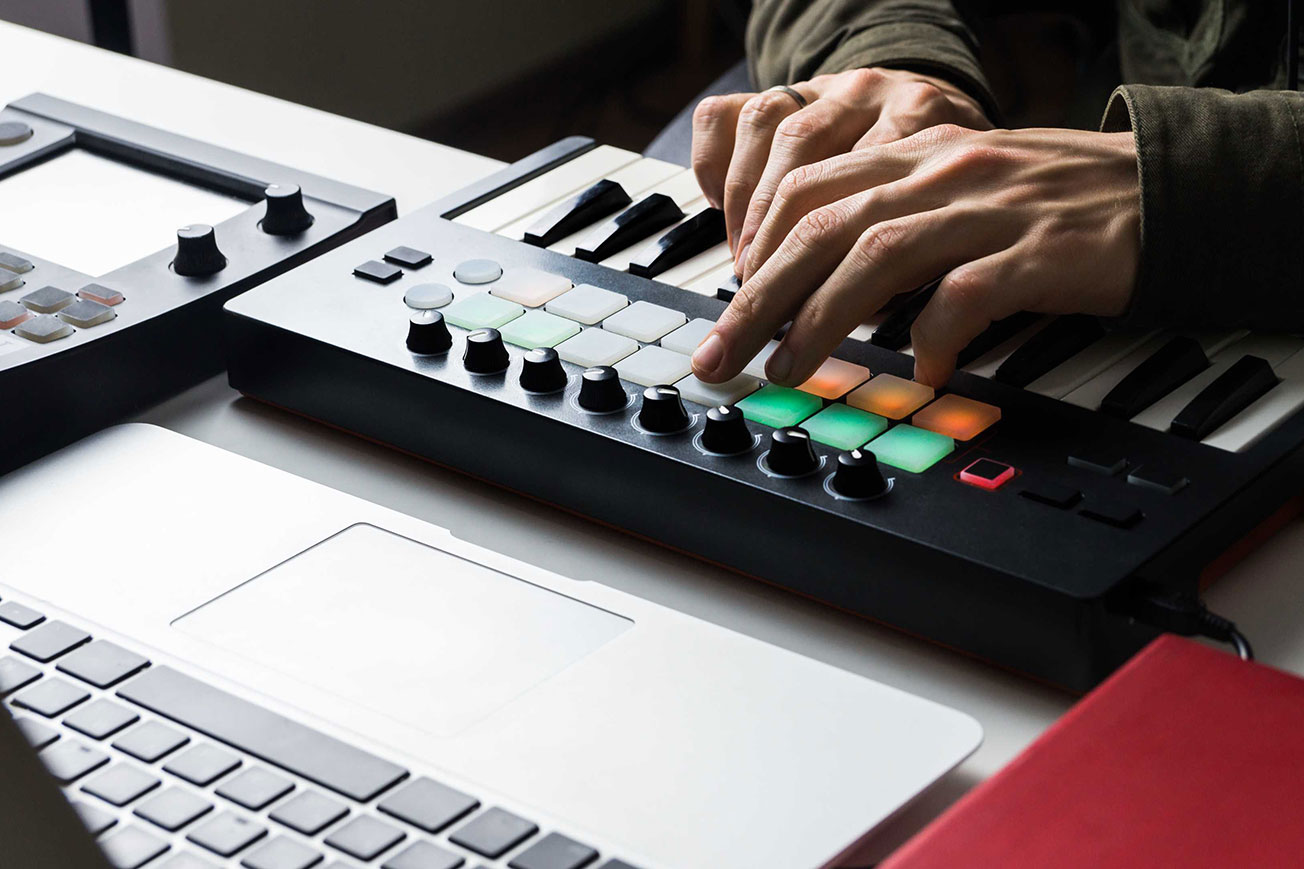 Music Producer Playing MIDI Keyboard in Home Studio
